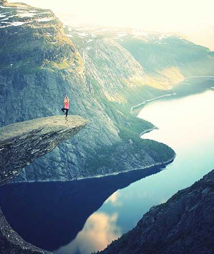 Girl do yoga over a cliff