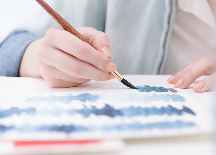 هنرمند در حال نقاشی با قلم مو